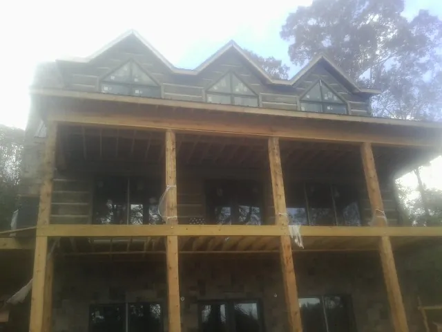 Dormers and porch framing on a large log home under construction — Roof Coating work by our crew in Chesnee