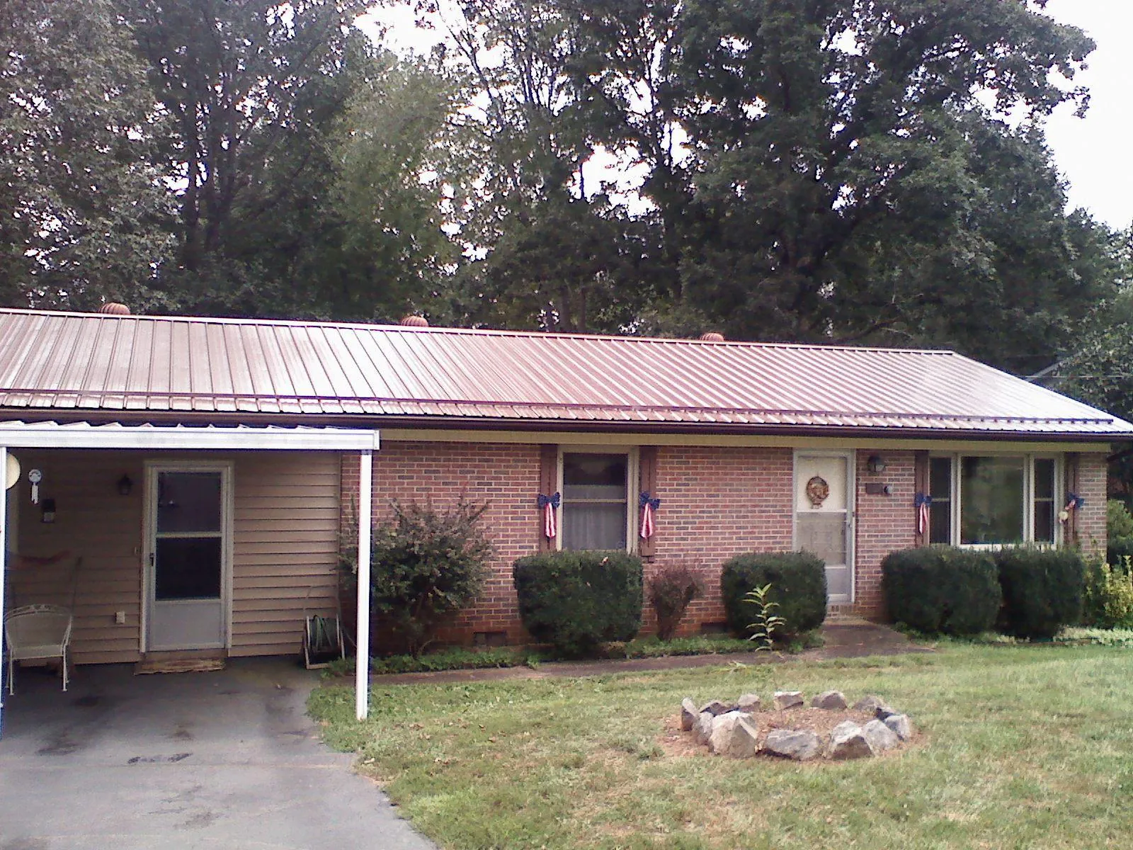 Bronze metal roof and carport on a brick ranch home — Roof Repair work by our crew in Chesnee